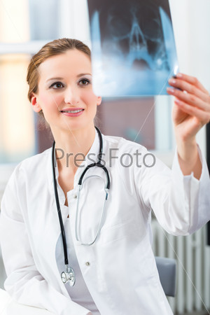 Radiology - female Doctor looking at a tomography x-ray picture of a skull, stock photo