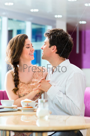 loving couple in a cafe or ice cream parlor spends leisure time together hugging and kissing