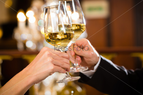 happy couple have a romantic date in a fine dining restaurant they drink wine and clinking glasses, cheers - closeup