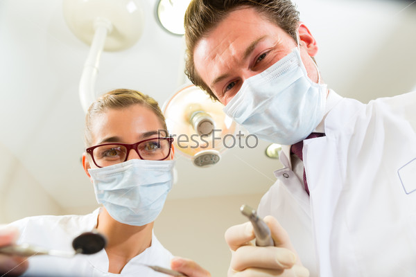 Dentist and assistant at a treatment, from the perspective of a patient