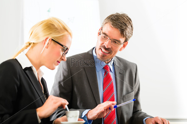 Business - Two businesspeople or professionals have a conversation in an office and drinking coffee or espresso