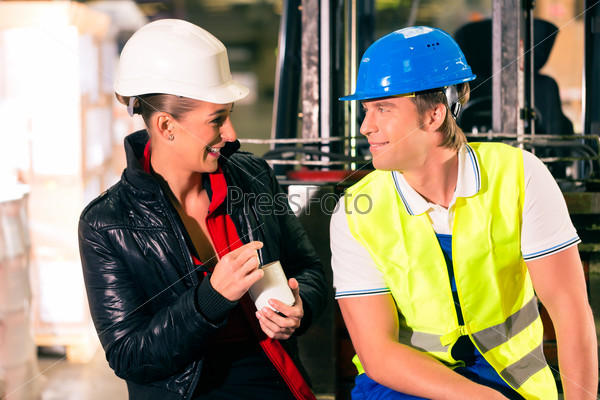 Forklift driver and female coworker takes a break at warehouse of freight forwarding company