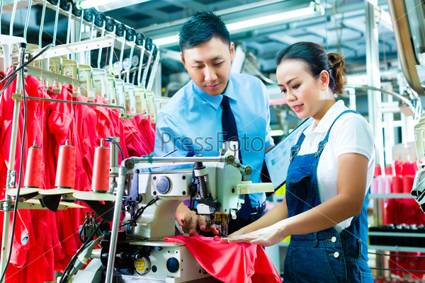 Seamstress is new assigned to a machine in a textile factory, the foreman explains something