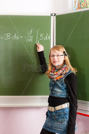 Education - Child or pupil at blackboard in school in math