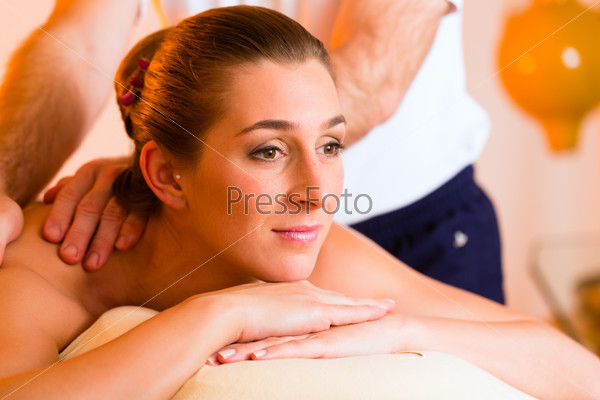 Woman enjoying a wellness back massage in a spa, she is very relaxed
