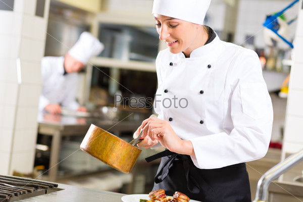 Female Chef in hotel or restaurant kitchen cooking, she is working on the sauce as saucier