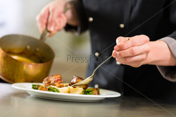 Chef In Hotel Or Restaurant Kitchen Cooking, Only Hands To Be Seen, He Is Working On The Sauce For The Food As Saucier