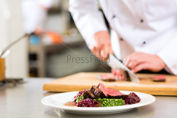 Шеф-повар в гостинице или ресторане режет мясо