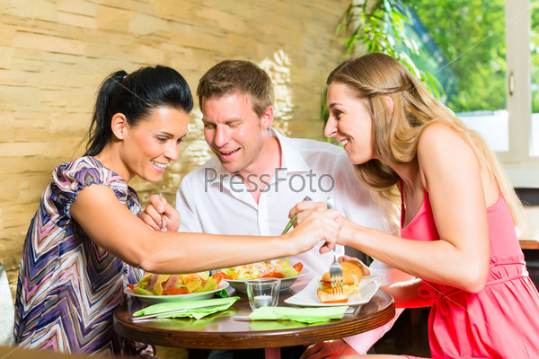 Man and women, perhaps colleagues or friends eating together healthy lunch or breakfast and taste from each others plate