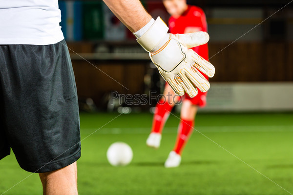 Man scoring a goal at indoor football or indoor soccer, stock photo