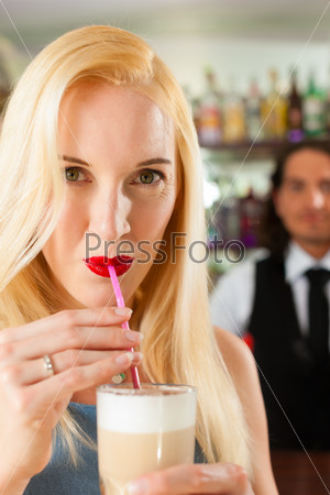 Coffeeshop - barista in cafe with a female attractive client, she is drinking coffee