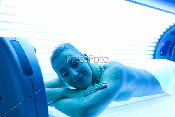 Young woman lying on tanning bed for a beautiful complexion