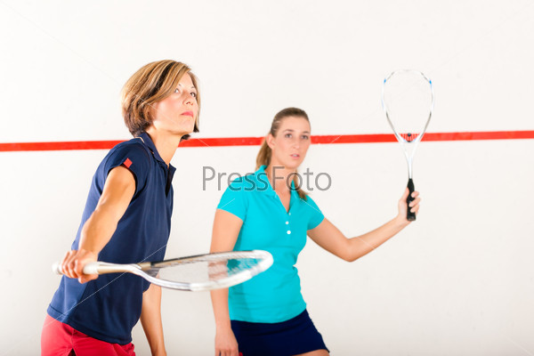 Две женщины играют в сквош в зале