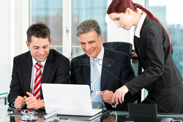 Business - team meeting in an office with laptop, the boss with his employees, stock photo
