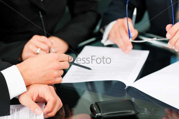 Business - meeting in an office; lawyers or attorneys (only hands) discussing a document or contract agreement