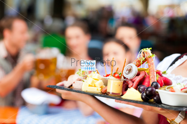 Beer garden restaurant in Bavaria, Germany - beer and snacks are served, focus on meal, stock photo