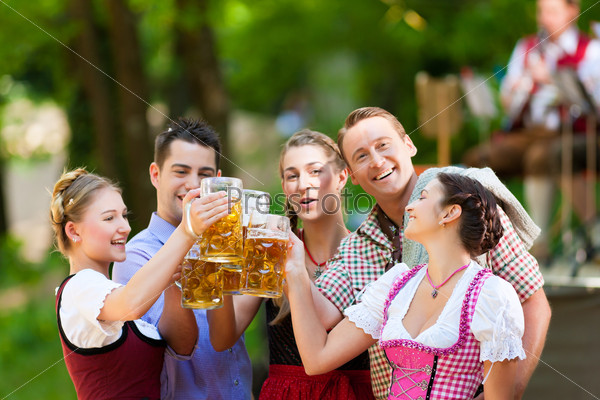 Компания друзей в пивном саду пьет пиво в Баварии, Германия