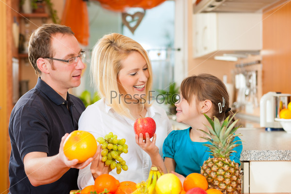 Family (mother, father and child) with lots of fruits for breakfast food, this is healthy nutrition