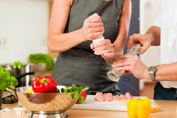 Man and woman in the kitchen - they preparing the vegetables and salad for dinner or lunch