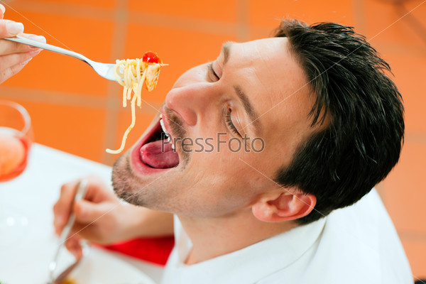 Couple at lunch or dinner; she is feeding him with spaghetti