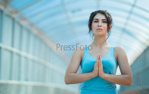Young mixed woman in the prayer position