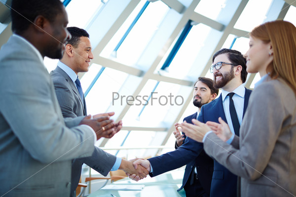 Group of business people congratulating their colleagues with striking grand deal