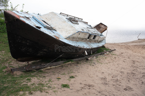 Old deserted boat on the sand lake bank, stock photo