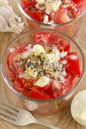 cold tomato salad with chopped onion, garlic and crushed black pepper