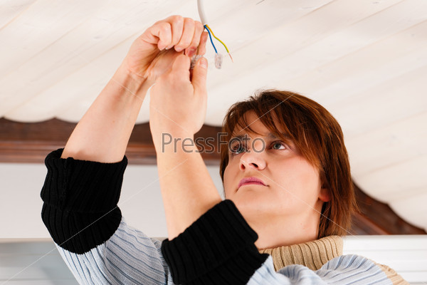Female worker doing work on electrical installation