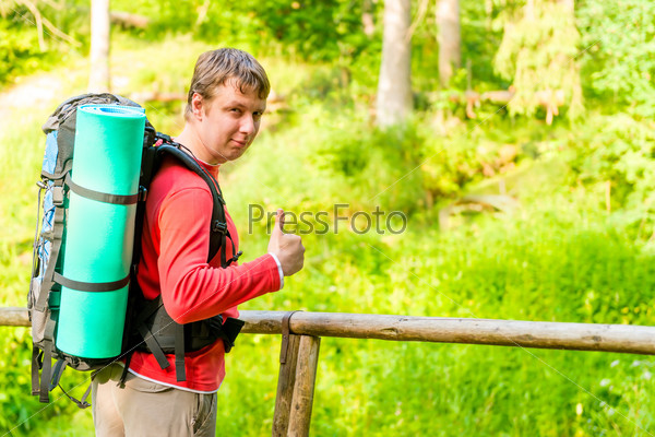 Satisfied man goes camping in the woods, stock photo
