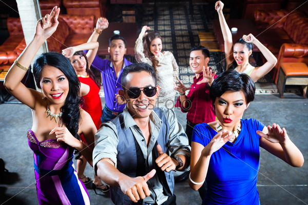 Asian party people men and women partying on the dance floor in fancy night club, stock photo