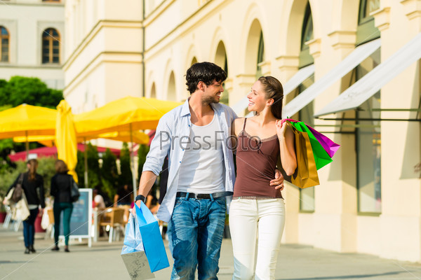 Young couple shopping in inner city with shopping bags spending money