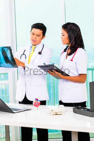 Asian doctor and nurse working in medical office or practice