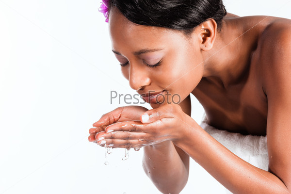 Young African woman in Studio doing body care with fresh water for young and beautiful skin
