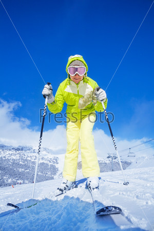 Happy young woman standing and bending to camera on the mountain slope