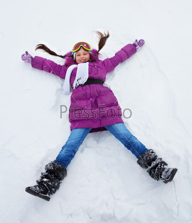 Girl laying in star shape in snow