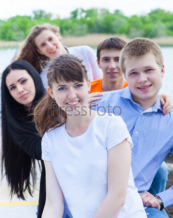 Group of smiling teenagers standing outdoors. Friendship concept