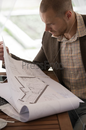 Businessman working blueprints cafe
