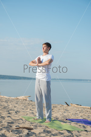Morning Yoga Meditation at the Beach by man