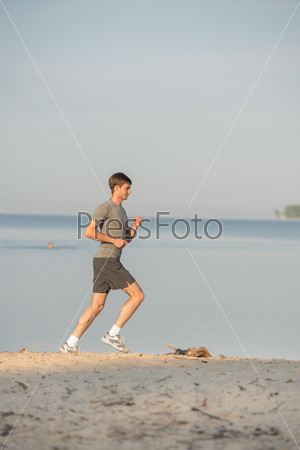 Man athlete/runner running on beach - jog workout well-being concept