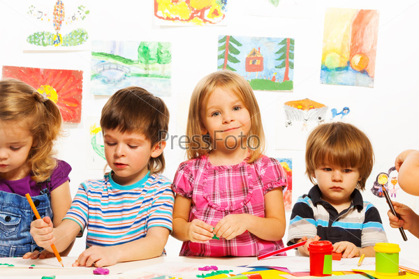 Group of little kids on painting class sitting together with pencils and paints