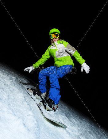 Young woman on snowboard at night