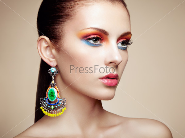 Portrait of beautiful young woman with earring Jewelry and accessories Perfect makeup Fashion photo