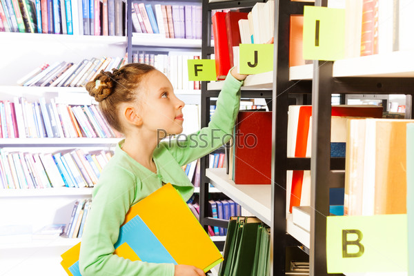 Girl looking and searching books in library