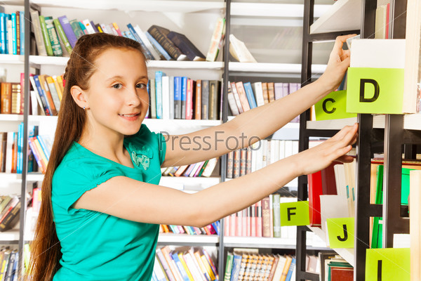 Girl with long hair searches book and smiles