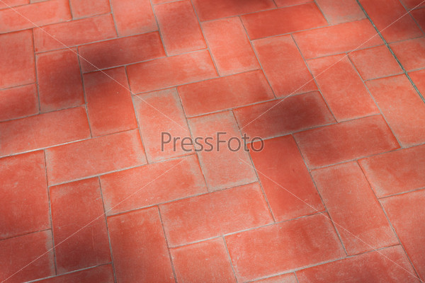 Red floor tiles with shadows from trees
