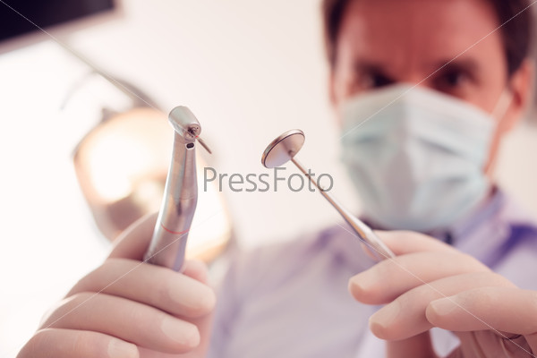 Stomatologist holding dental tools