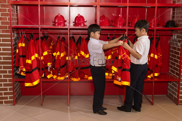 Boys trying on fireman uniform