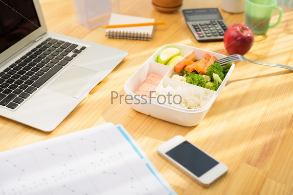 Plastic container with healthy food on the office table