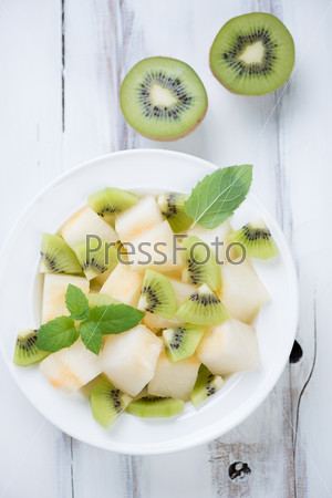 Above view of summer salad with melon, kiwi fruit and mint
